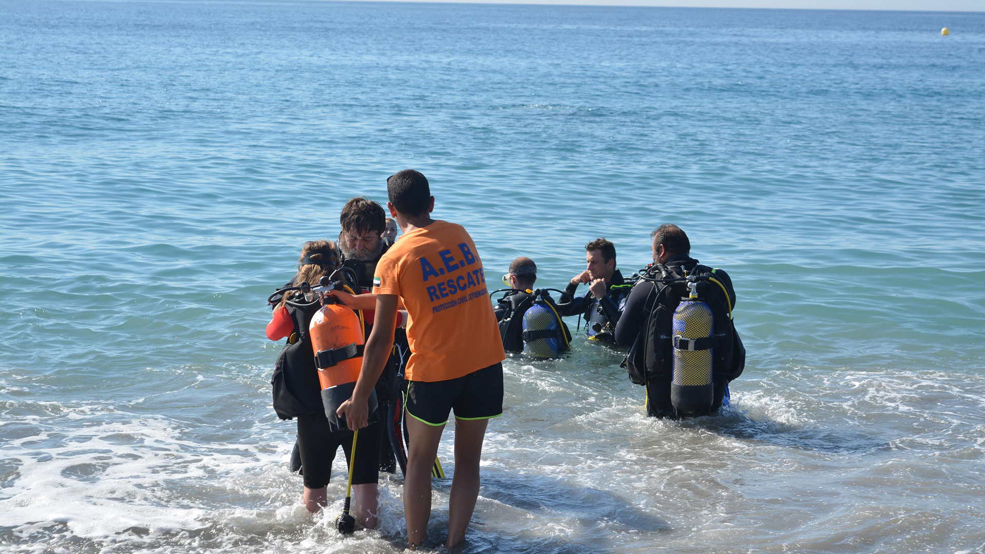 Fotografía participantes e instructores en mar iniciación curso buceo