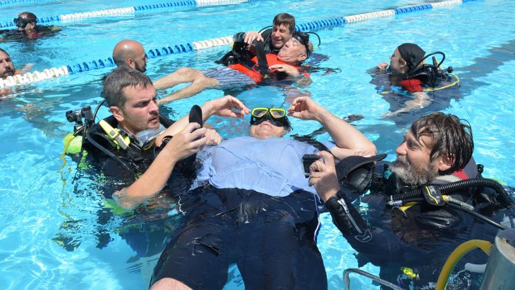 Fotografía participantes e instructores en piscina iniciación curso buceo