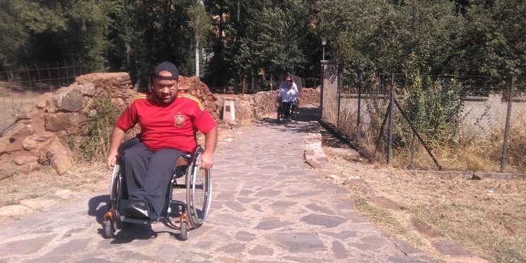 fotografía asistente a las jornadas, en silla de ruedas por pavimento pedregoso
