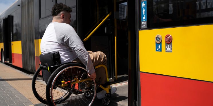 Fotografía decorativa de una persona en silla de ruedas subiendo a un autobús