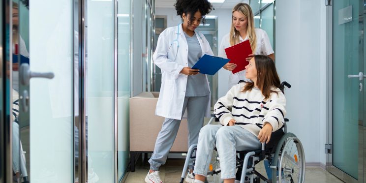 Fotografía decorativa persona en silla de ruedas con médicas