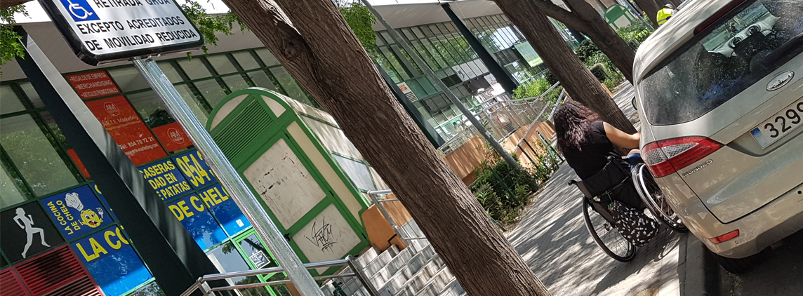 Fotografía de una trabajadora de FAMS-COCEMFE Sevilla se prepara para subir a su vehículo estacionado en una de las plazas reservadas para persona con movilidad reducida