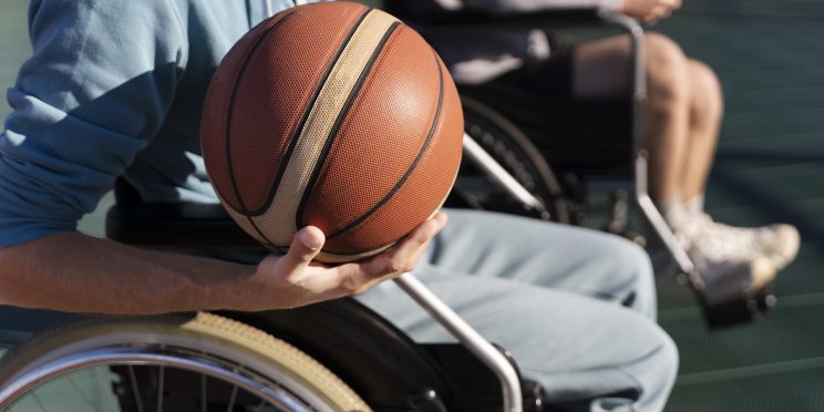 Fotografía decorativa personas en silla de ruedas practicando baloncesto adaptado